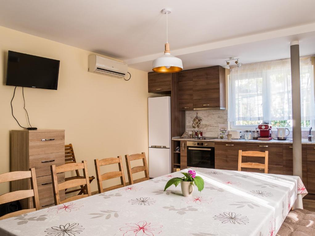 uma cozinha com uma mesa com um vaso de flores em Simada Green Guesthouse em Varshets