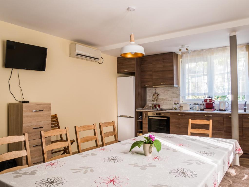 a kitchen with a table with a vase of flowers on it at Simada Green Guesthouse in Varshets