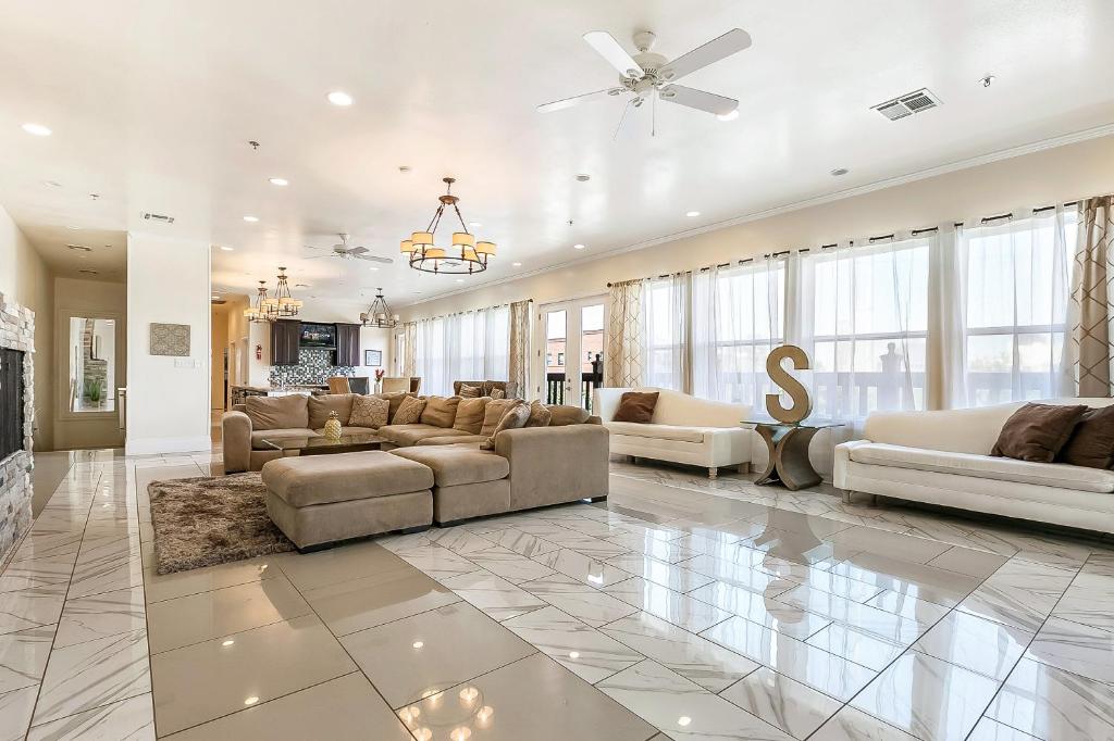 una gran sala de estar con sofás y ventilador de techo. en Modern, Spacious Condos with Luxury Amenities, en Nueva Orleans