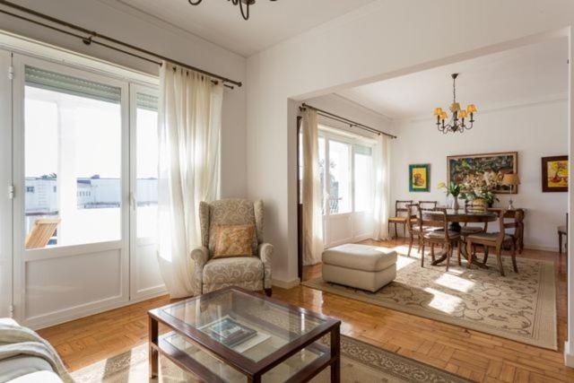 ein Wohnzimmer mit einem Tisch und einem Esszimmer in der Unterkunft Carcavelos - Holiday Beach Apartment in Carcavelos