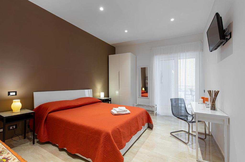 ローマにあるMartoglio5のベッドルーム1室(オレンジ色の毛布と椅子付きのベッド1台付)