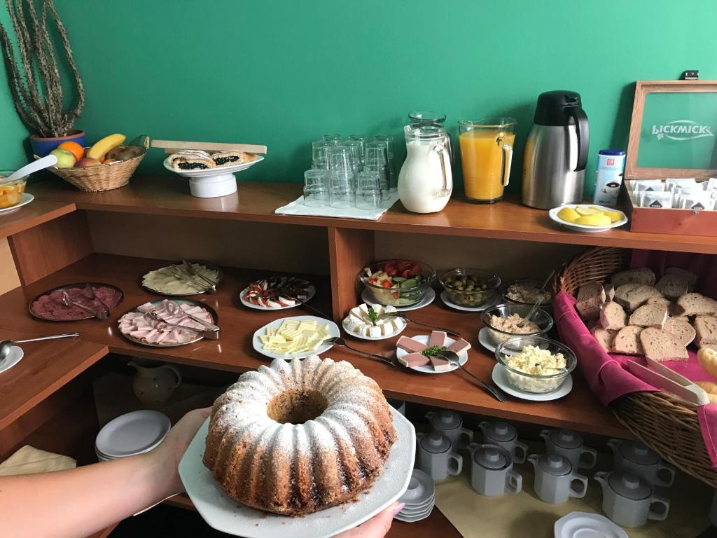 a person holding a plate with a table full of food at Hotel Boston in Karlovy Vary