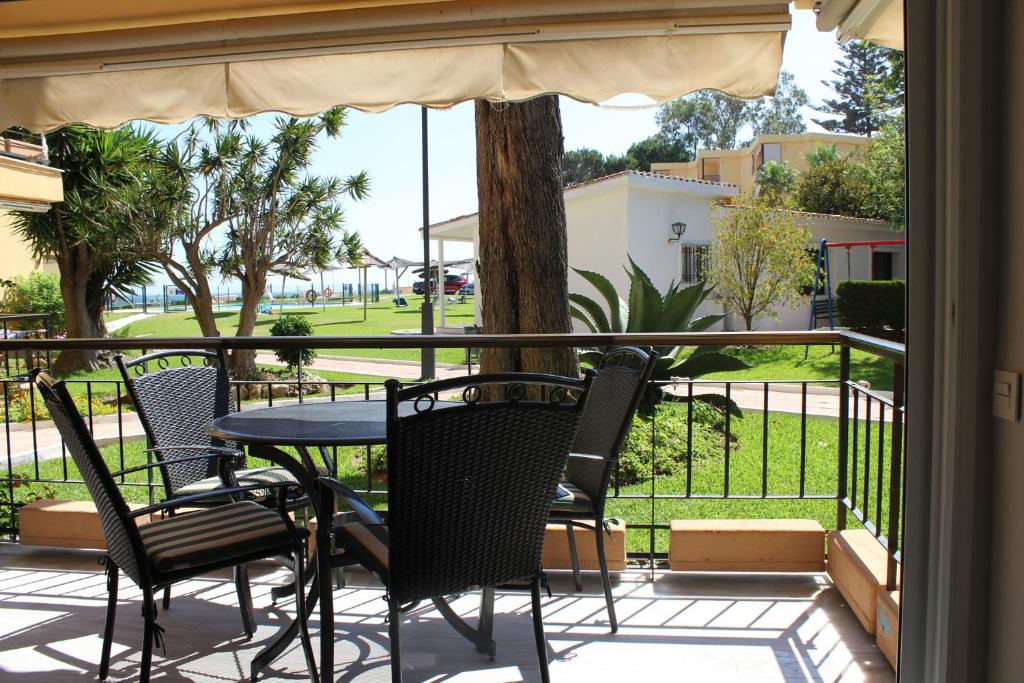 eine Terrasse mit einem Tisch und Stühlen auf dem Balkon in der Unterkunft Playa Bella 3-1E in Estepona