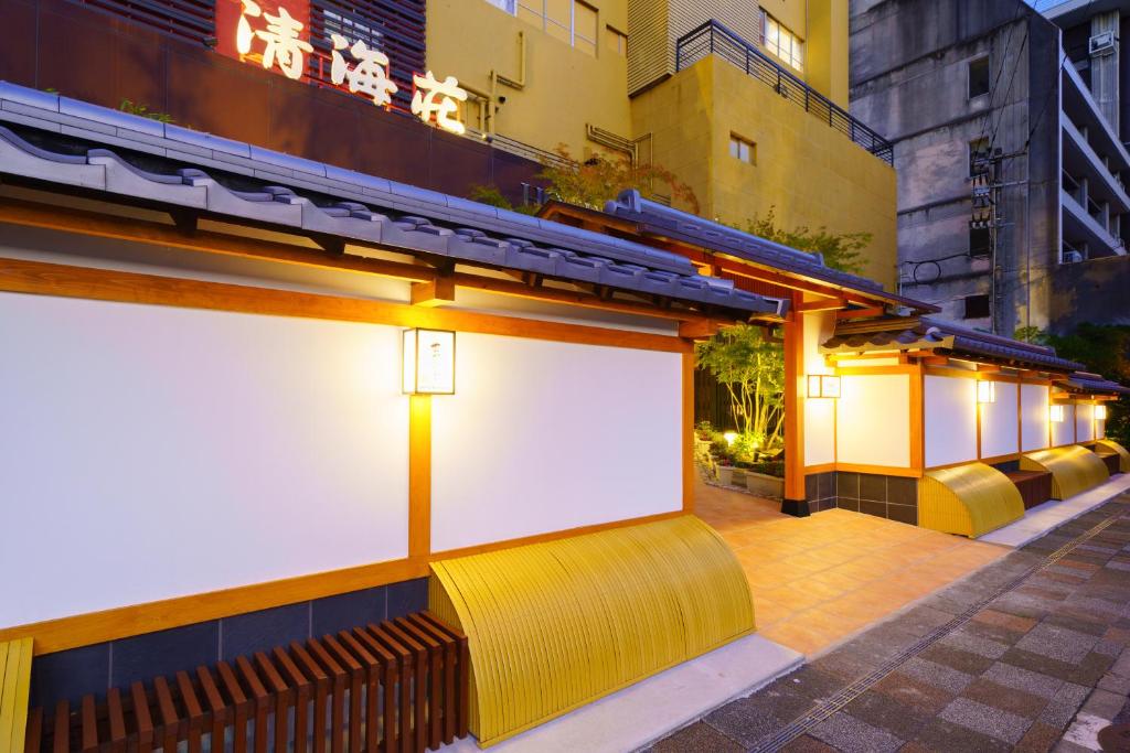 um edifício com um sinal branco na lateral em Tenku Yubo Seikaiso em Beppu