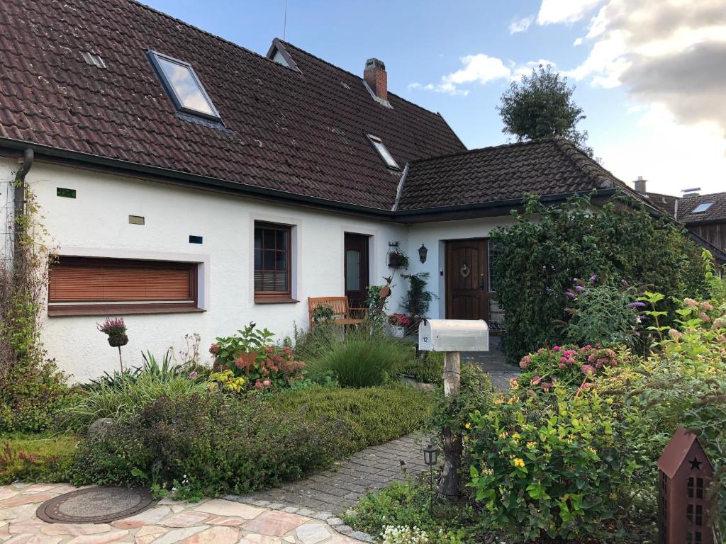 ein weißes Haus mit einem Garten davor in der Unterkunft Ferienwohnung 2 Basthorst in Basthorst