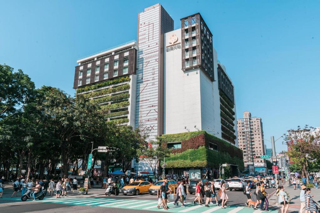 una multitud de personas cruzando una calle en una ciudad en Star Hostel Taichung Parklane, en Taichung