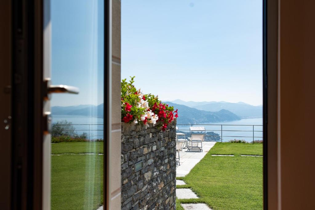 a door to a balcony with flowers on a wall at Il Leccio - Luxury Resort Portofino Monte in Santa Margherita Ligure
