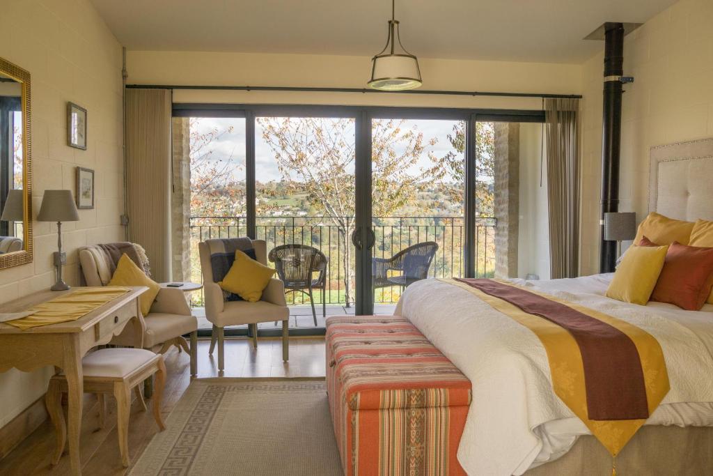 1 dormitorio con 1 cama grande y balcón en Vineyard Barn Room en Stroud