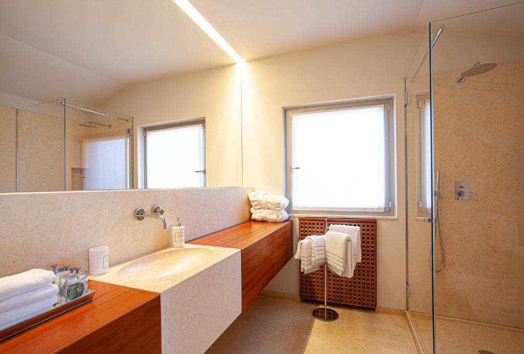 a bathroom with a sink and a glass shower at Il Leccio - Luxury Resort Portofino Monte in Santa Margherita Ligure