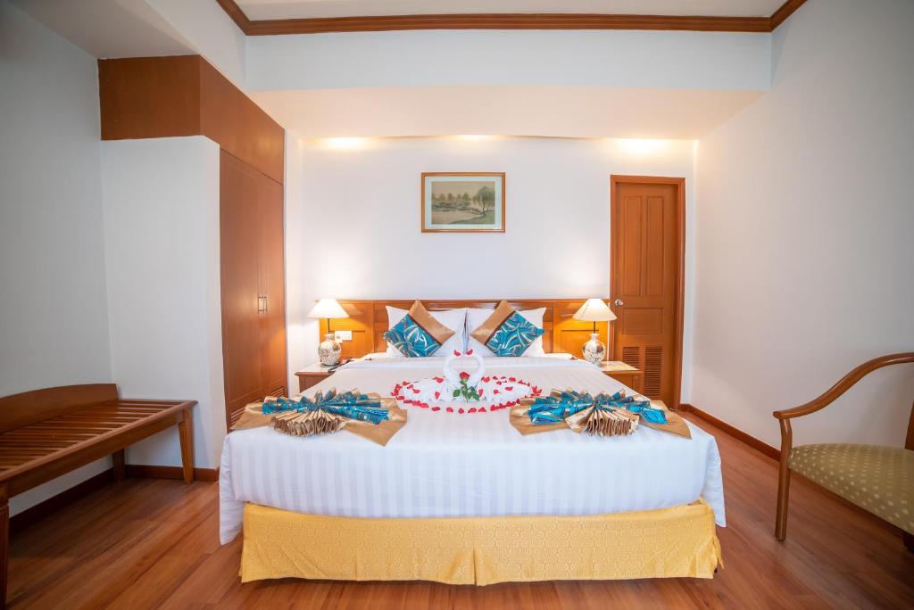 een slaapkamer met een groot wit bed met een bloem erop bij Oscar Saigon Hotel in Ho Chi Minh-stad