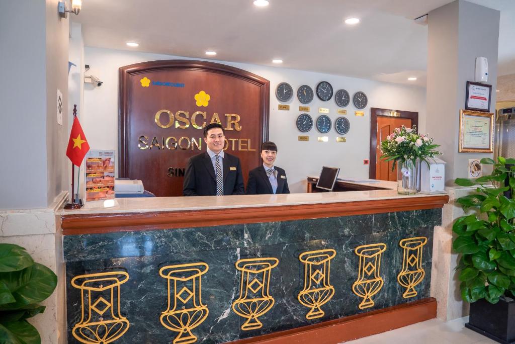 two men standing at a bar in a restaurant at Oscar Saigon Hotel in Ho Chi Minh City