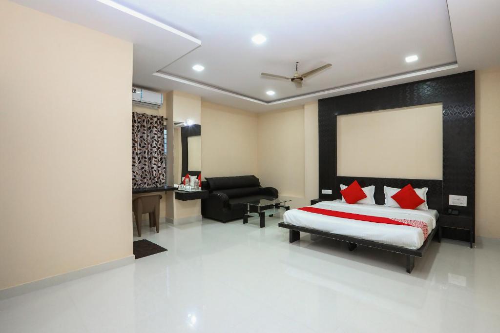ein Schlafzimmer mit einem Bett und ein Wohnzimmer in der Unterkunft Suvarna Suits in Mysore