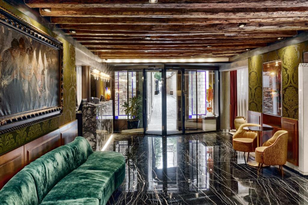 a living room with a green couch and a table at Hotel Bisanzio in Venice