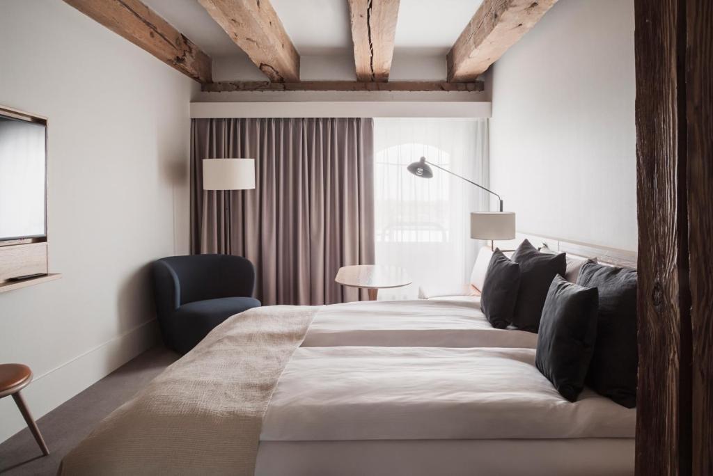 a bedroom with a large bed and a blue chair at Copenhagen Admiral Hotel in Copenhagen