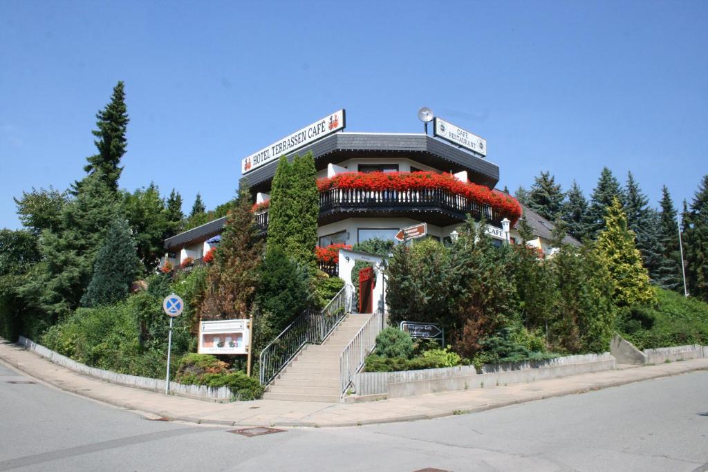 um edifício com plantas ao lado de uma rua em Themen Hotel Terrassen Cafe em Bad Münder am Deister