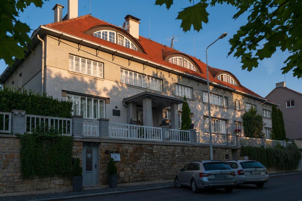 a building with two cars parked in front of it at Art Deco Hotel Hoffmann in Kladno