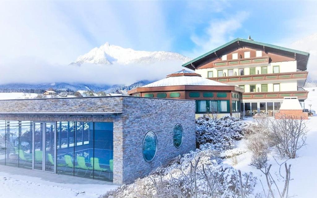 a building in the snow in front of a mountain at Berghof Mitterberg in Gröbming