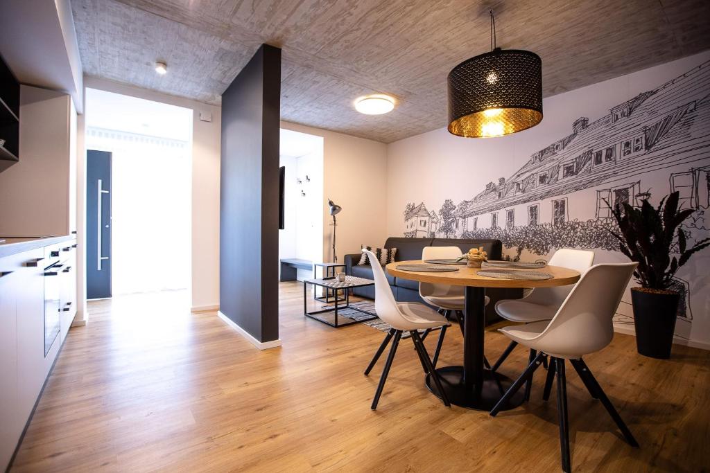 Una cocina y un comedor con mesa y sillas. en Postcard City Apartments, en Maribor