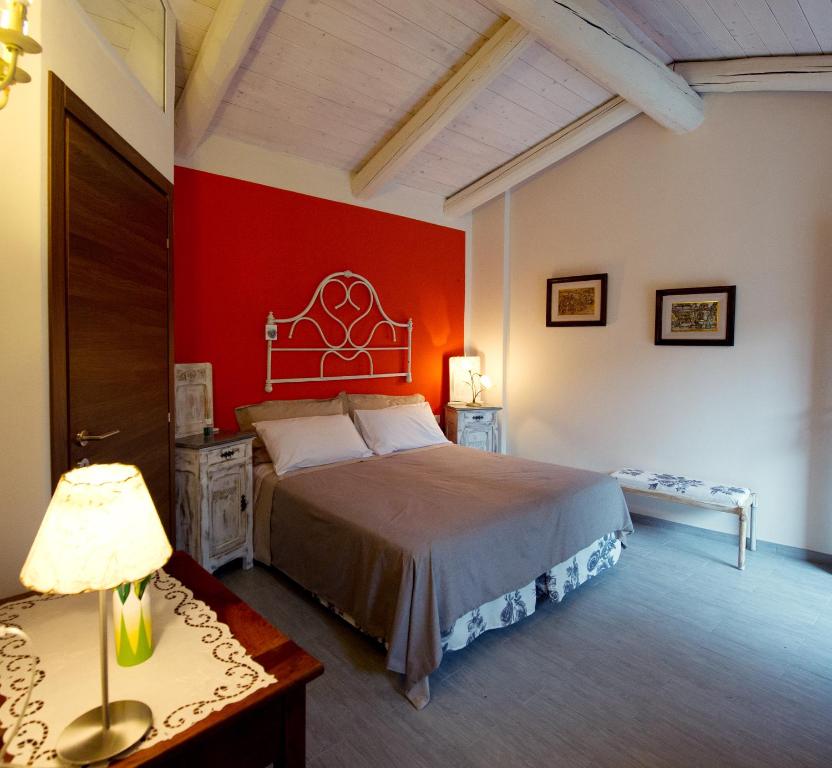 1 dormitorio con cama y pared roja en La Ida Bed and Breakfast, en Villareggia