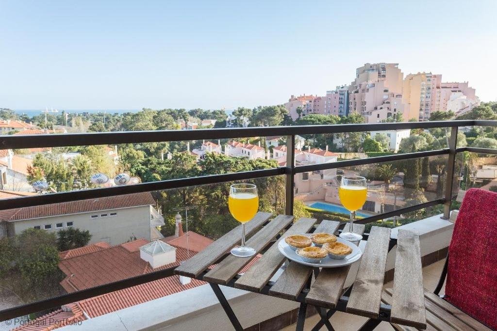 una mesa con dos vasos de zumo de naranja y galletas en Cascais Panoramic Apartment en Cascais