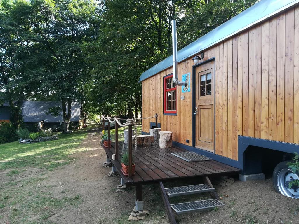 ein kleines Haus auf einer Holzterrasse in der Unterkunft Benno der Zirkuswagen in Tettau