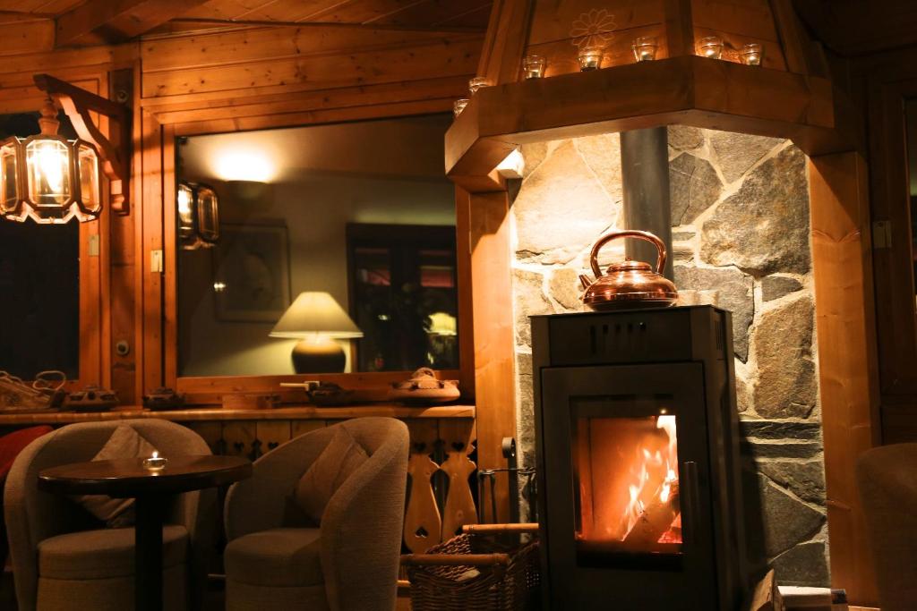a fireplace in a room with chairs and a table at Hotel & Spa Le Dahu in Morzine