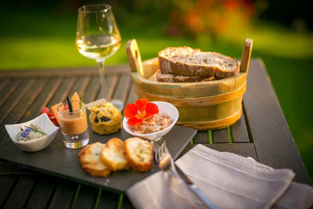 a table with a plate of bread and a glass of wine at Hotel & Spa Le Dahu in Morzine