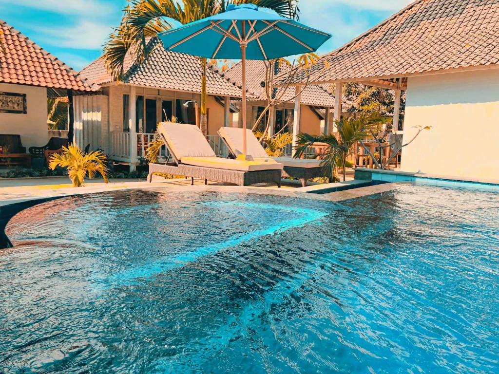 uma piscina com um guarda-sol azul e cadeiras em The Lucky Cottage em Nusa Lembongan