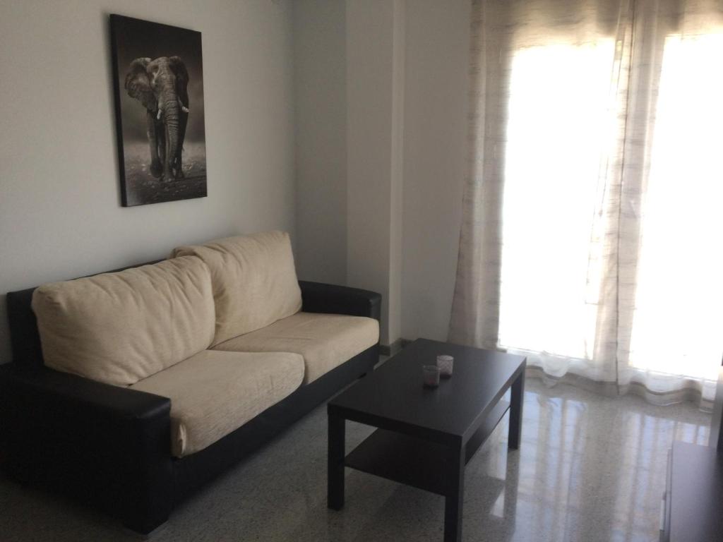 sala de estar con sofá y mesa en Apartamento de una habitación, en Málaga