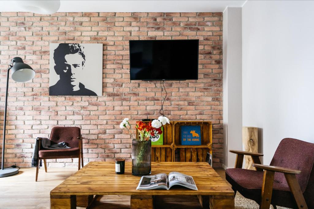 - un salon avec un mur en briques dans l'établissement Harmonica Home by LoftAffair, à Cracovie