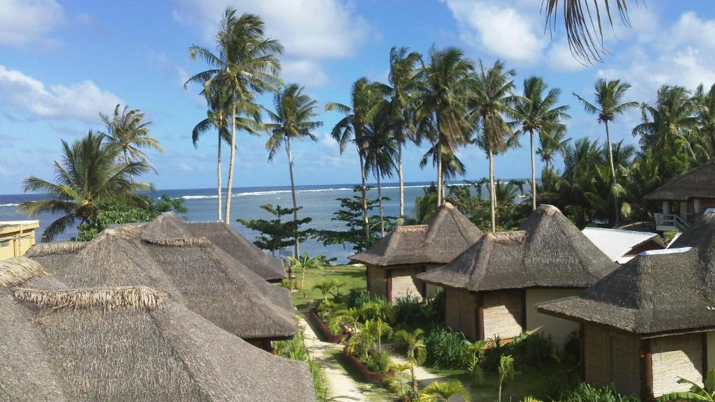 a view of a resort with thatched roofs and the ocean at Jonas and Twins Resort in General Luna