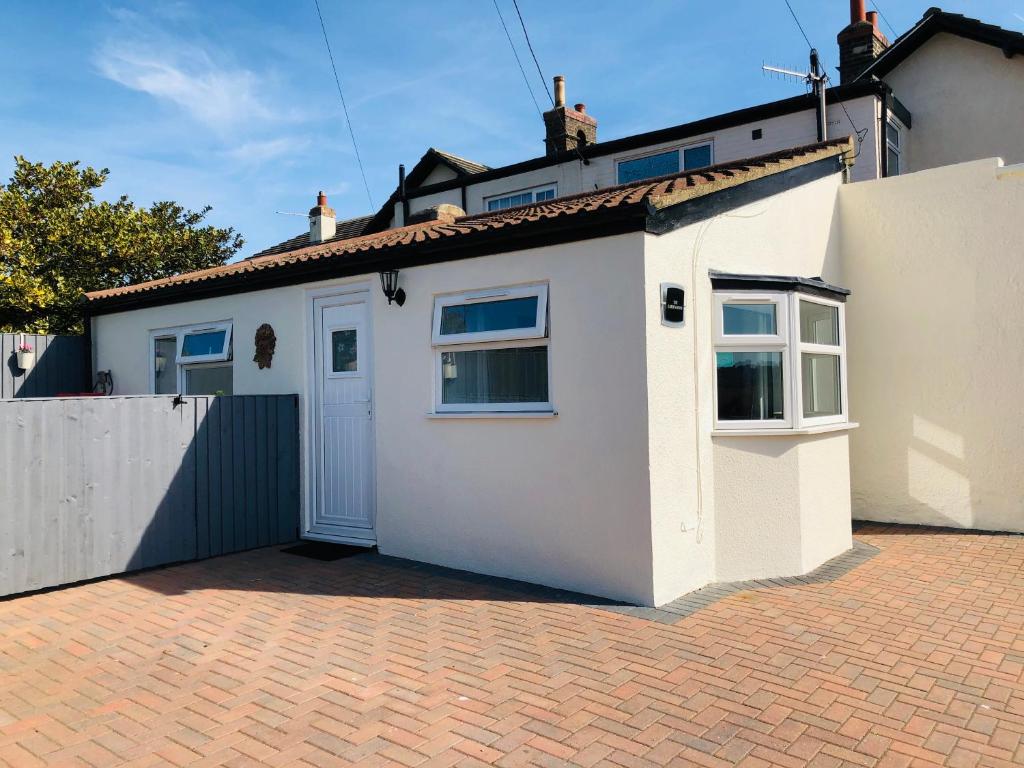ein weißes Haus mit einer weißen Tür auf einer steinernen Einfahrt in der Unterkunft The Garden Room in Filey