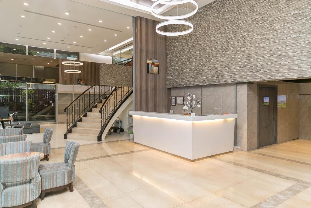 a lobby with chairs and a counter and stairs at Hotel Leisure Beitou in Taipei