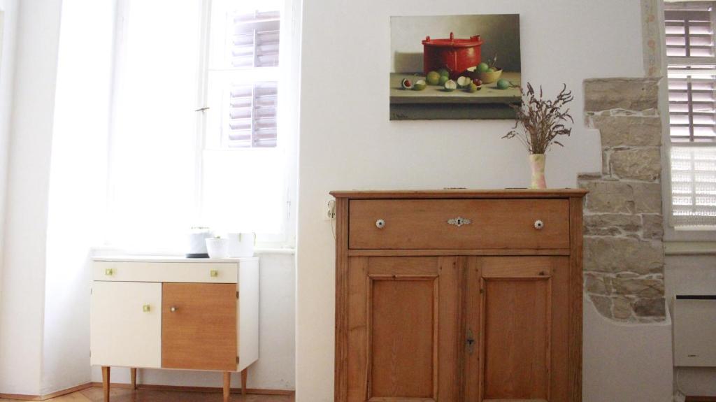 eine Küche mit einem Holzschrank neben einer Wand in der Unterkunft In the center & nice & quiet in Pula