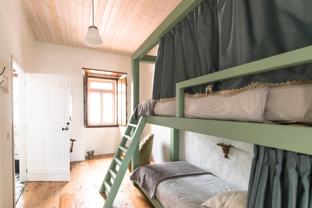 a bedroom with two bunk beds and a window at Bohemian Antique Guesthouse in Odeceixe