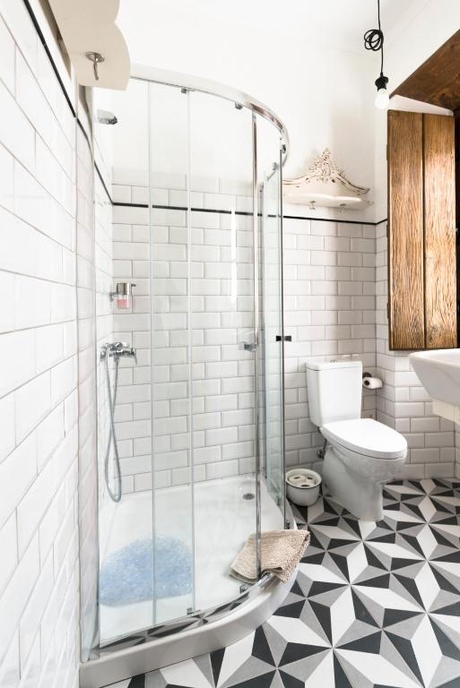 a glass shower in a bathroom with a toilet at Bohemian Antique Guesthouse in Odeceixe