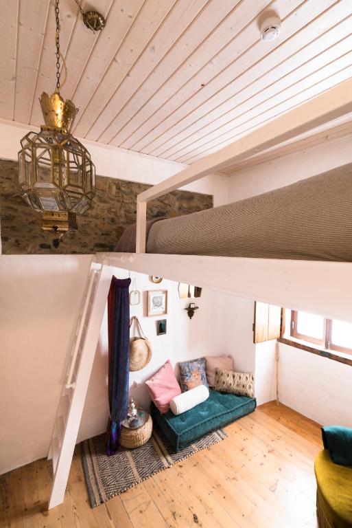 a room with a couch under a loft bed at Bohemian Antique Guesthouse in Odeceixe