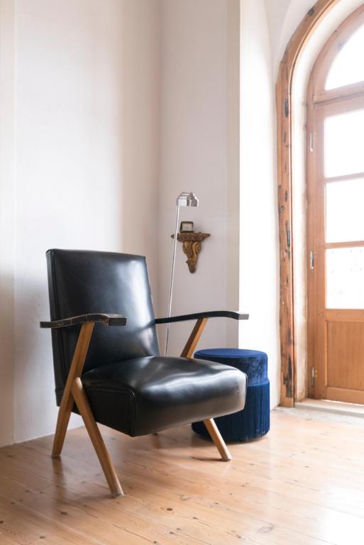a black leather chair sitting in a room at Bohemian Antique Guesthouse in Odeceixe