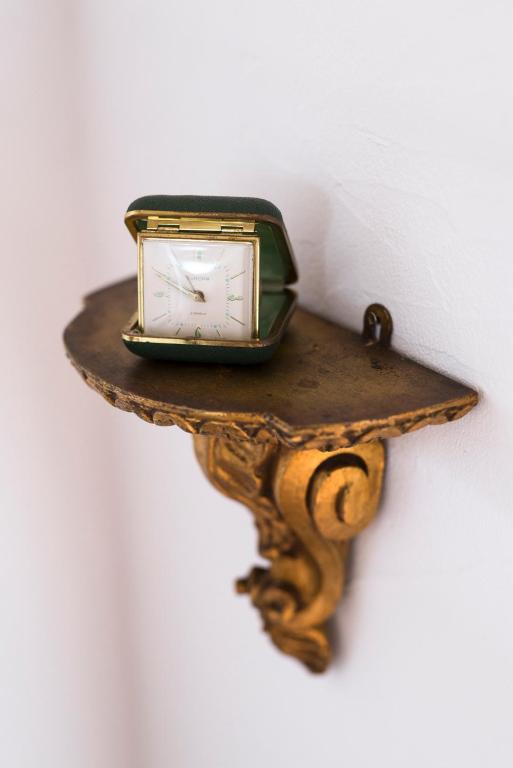 a clock sitting on a shelf on a wall at Bohemian Antique Guesthouse in Odeceixe