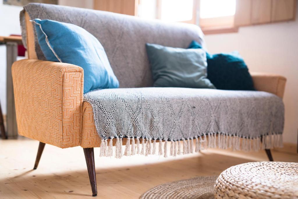 a wicker chair with pillows on it in a living room at Bohemian Antique Guesthouse in Odeceixe