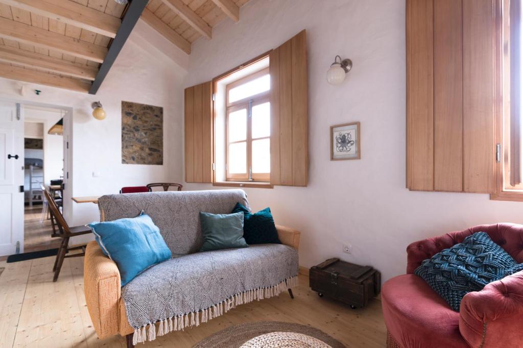 a living room with a couch and a chair at Bohemian Antique Guesthouse in Odeceixe