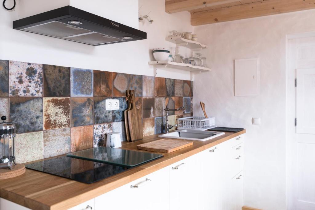 a kitchen with a counter with a sink and a stove at Bohemian Antique Guesthouse in Odeceixe