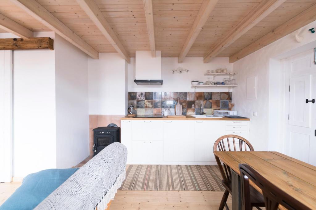 a kitchen with a couch and a wooden table at Bohemian Antique Guesthouse in Odeceixe