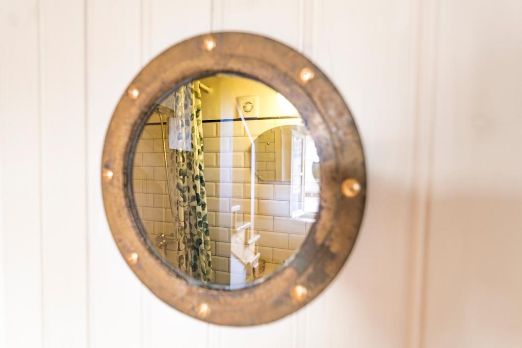 a mirror hanging on a wall in a bathroom at Bohemian Antique Guesthouse in Odeceixe