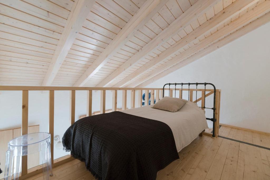 a bed in a room with a wooden ceiling at Bohemian Antique Guesthouse in Odeceixe