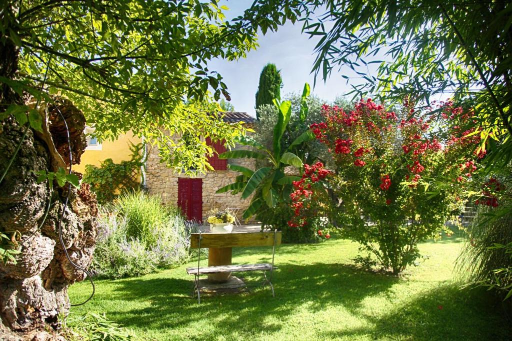 een tafel in het midden van een tuin met bloemen bij Bastide Sainte Agnès in Carpentras