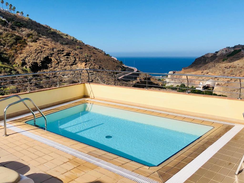 una piscina en la parte superior de una casa con el océano en Holiday Club Sol Amadores en Puerto Rico