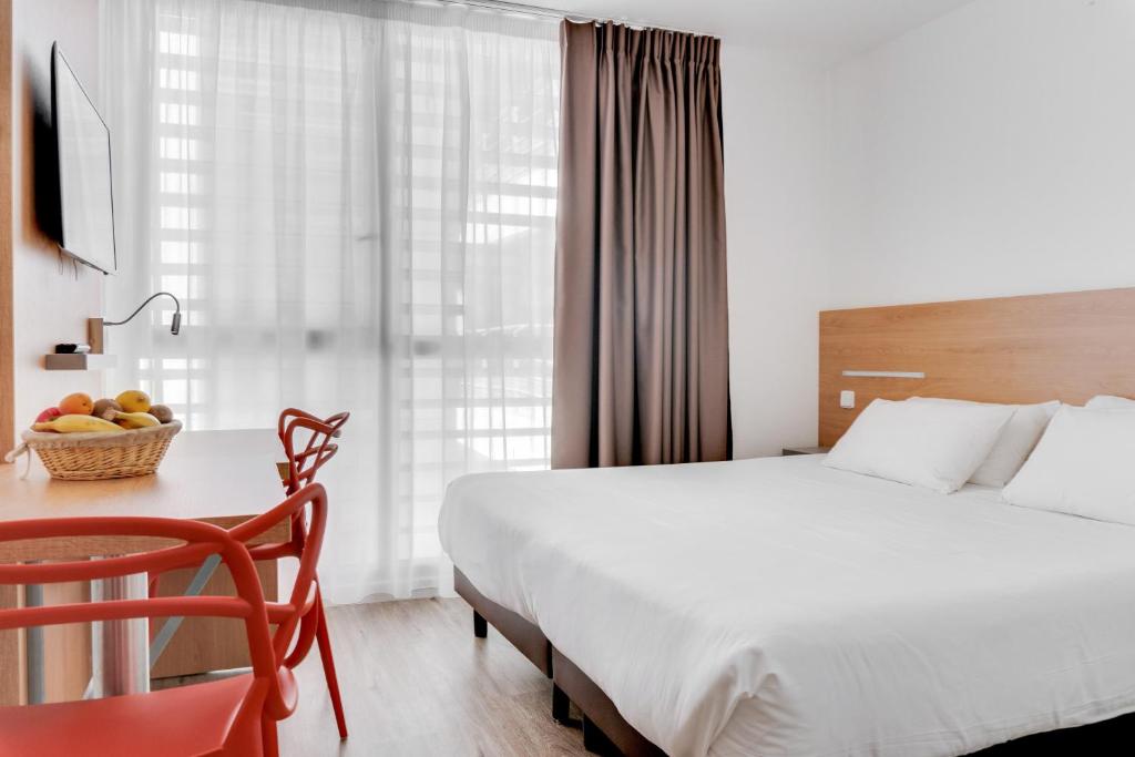 a hotel room with a bed and a table with a bowl of fruit at Residhotel Galerie Tatry in Bordeaux