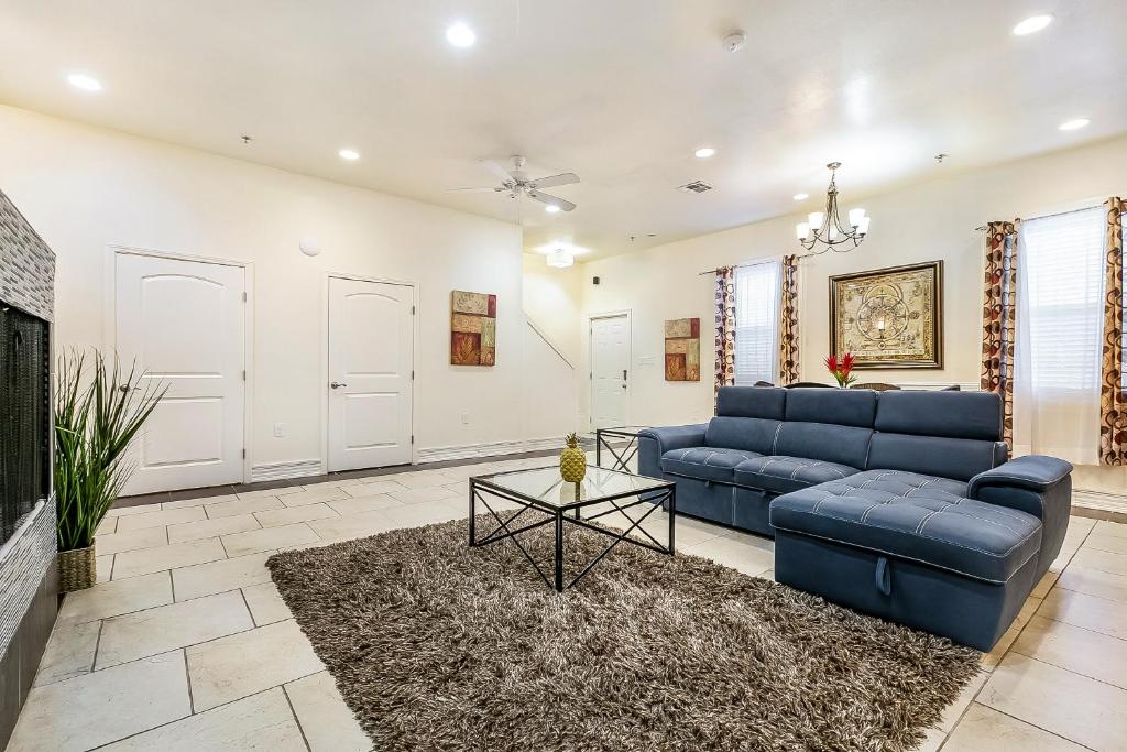 a living room with a blue couch and a table at Inviting 3BR Condo steps from St Charles Ave in New Orleans