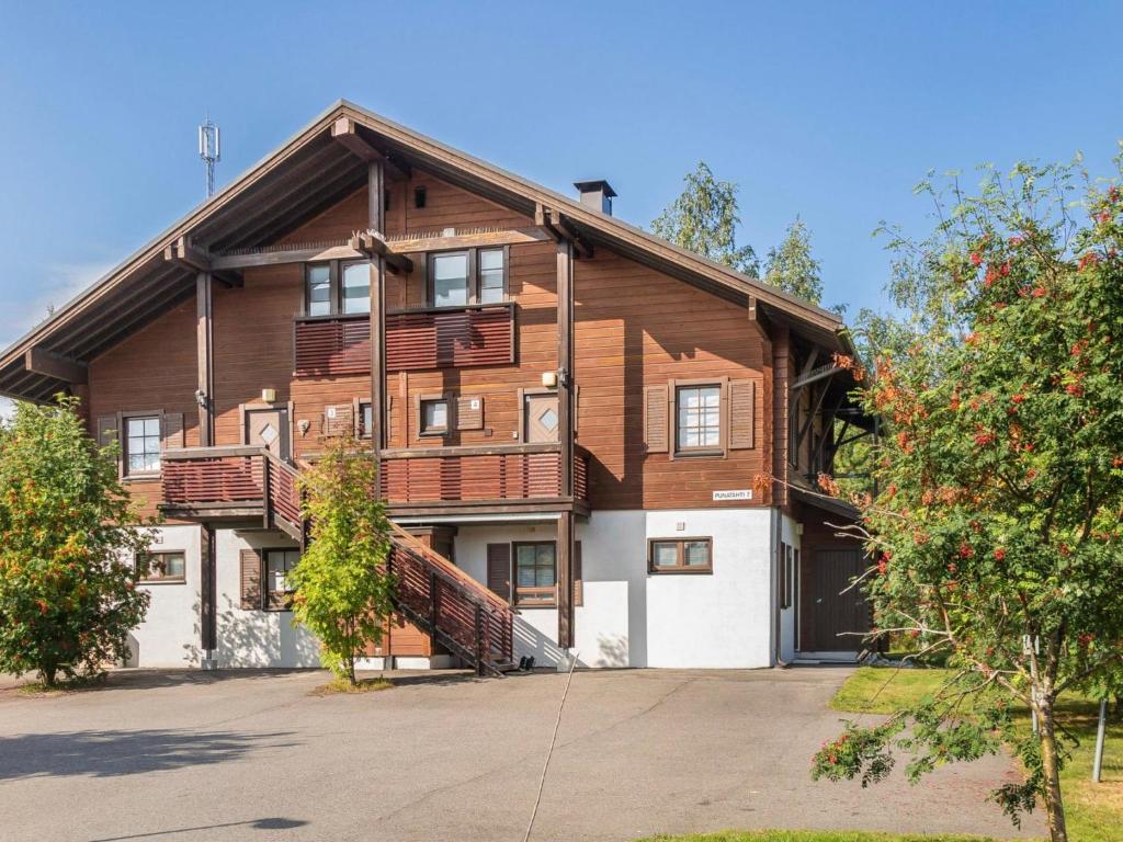 ein großes Holzhaus mit Auffahrt in der Unterkunft Holiday Home Alppitalo punatähti 7 apt 2 by Interhome in Tahkovuori